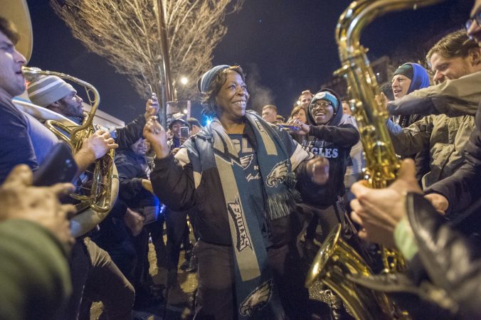 A woman dances as an impromptu brass band performs for the crowd.