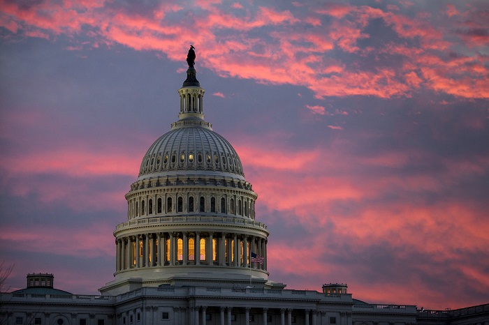 FILE - In this Thursday, Nov. 30, 2017, file photo, the sky over The Capitol is lit up at dawn  (AP Photo/J. Scott Applewhite, File)