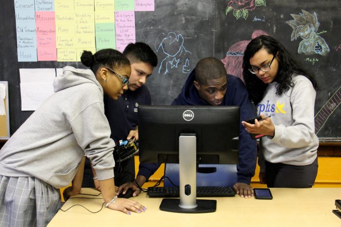 Cristo Rey students (from left) Catherine Santille, Ramiro Ortega-Zavaleta, Kemar Marshall and Maria Tejada Caceres  troubleshoot the programming for their team vehicle. (Emma Lee/WHYY)