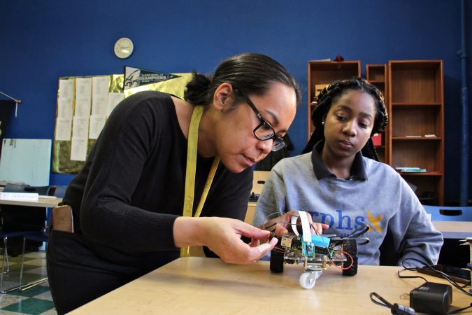 Engineering teacher Eva Porter helps Neriah Garrett with her prograammable vehicle. (Emma Lee/WHYY)