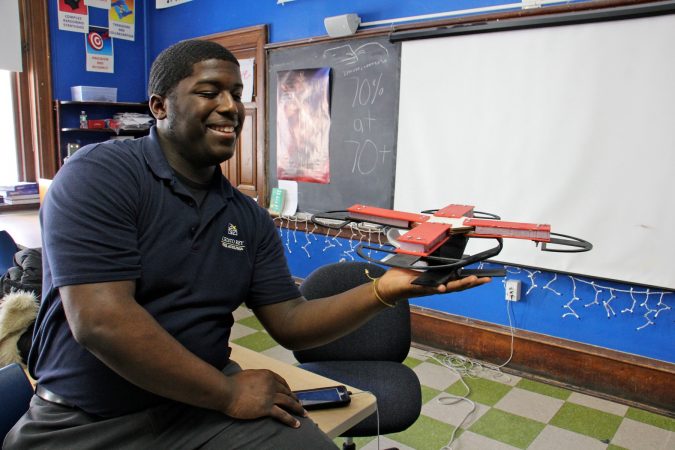 Cristo Rey student Kevin Riddick holds the drone frame he constructed during the first trimester of his autonomous systems engineering class. At the end of the third semester, he and his team will program and test fly the drone. (Emma Lee/WHYY)
