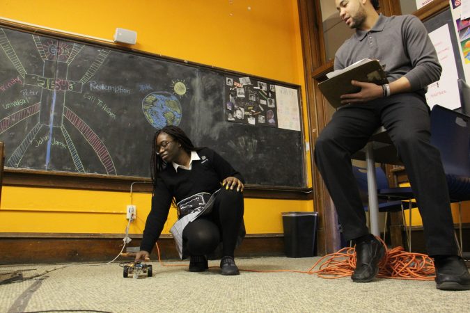 Cristo Rey student Monica Kpedenou demonstrates her program for monitor Jared Boyd during a timed test. (Emma Lee/WHYY)