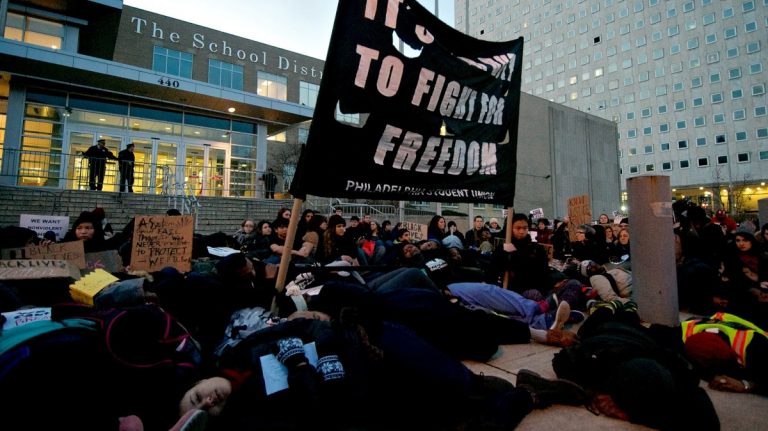 Close to a hundred students and members of the Philadelphia Student Union held a six-minutes 'Die-in' protest on the steps of the School District's North Broad Street headquarters. (Bas Slabbers/for WHYY, file)