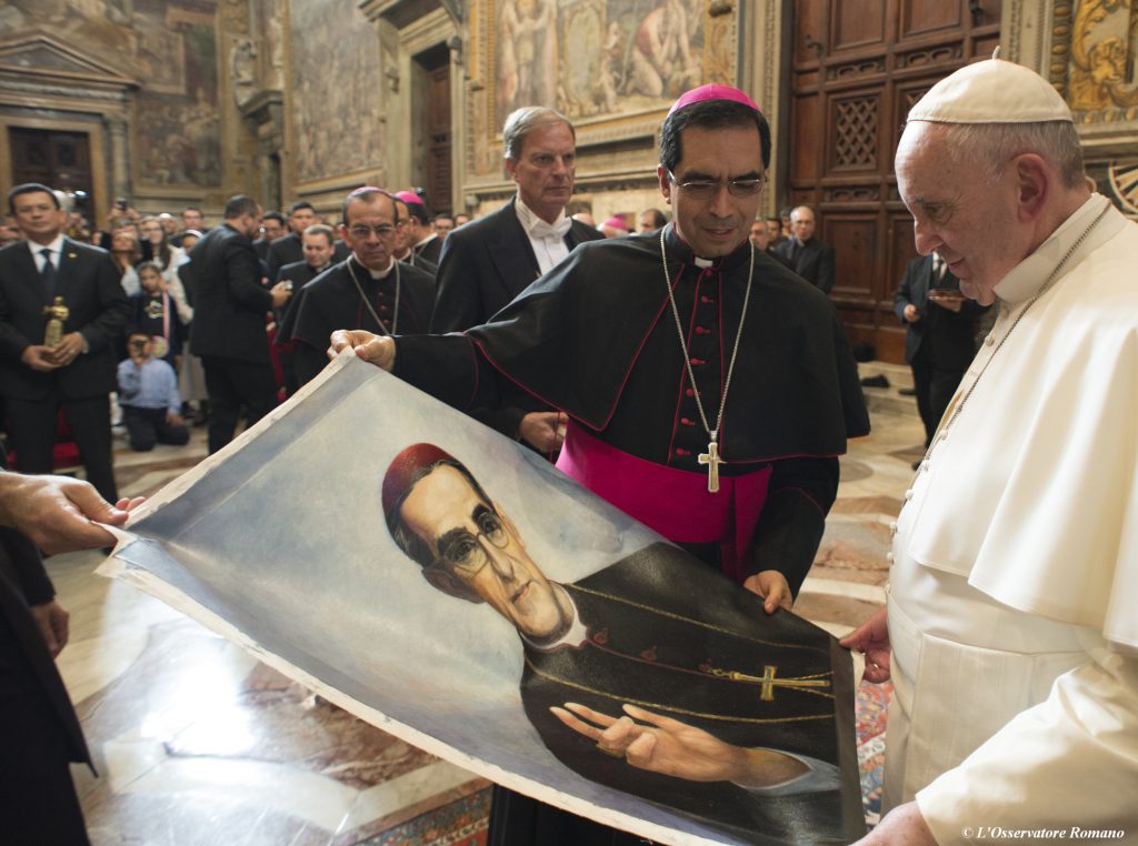 Vatican Romero Sainthood In 2015, Pope Francis is presented with an image of Roman Catholic Archbishop Oscar Romero during a private audience granted to participants to the pilgrimage from El Salvador at the Vatican. Pope Francis has cleared the way for slain Salvadoran Archbishop Oscar Romero to be made a saint, declaring that a churchman who stood up for the poorest of the poor in the face of right-wing oppression should be a model for Catholics today. (L'Osservatore Romano/Pool Photo via AP)