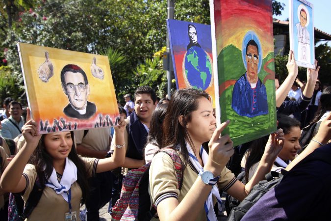 Students hold up art work depicting slain Salvadoran Archbishop Oscar Romero as they walk to the Divine Providence chapel, in San Salvador, El Salvador, Wednesday, March 7, 2018, where Romero was shot and killed as he celebrated Mass in 1980. Salvadorans are celebrating the news that Romero is to be made a saint. Pope Francis declared that the churchman who became a hero for standing up for the poor and oppressed should be canonized along with the reformer Pope Paul VI. (Salvador Melendez/AP Photo)