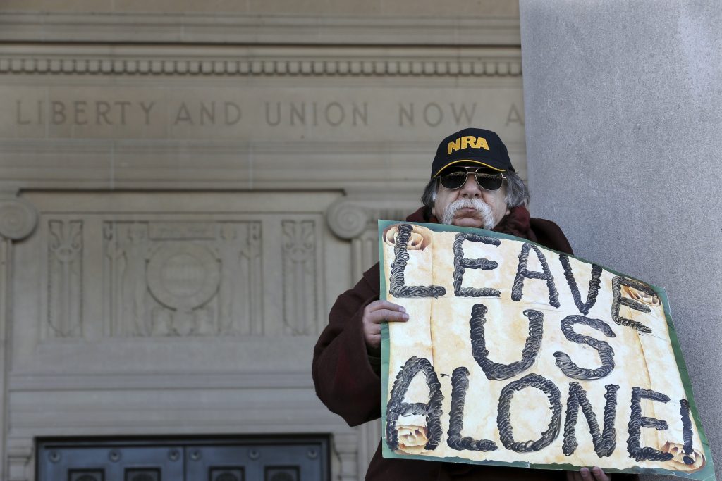 Gun Restrictions New Jersey A man holds a sign as he stands outside the War Memorial, near a group of Second Amendment advocates gathered in opposition to about a half-dozen gun control bills expected to get a vote in the Assembly on Monday, March 26, 2018, near the Statehouse in Trenton, N.J.
