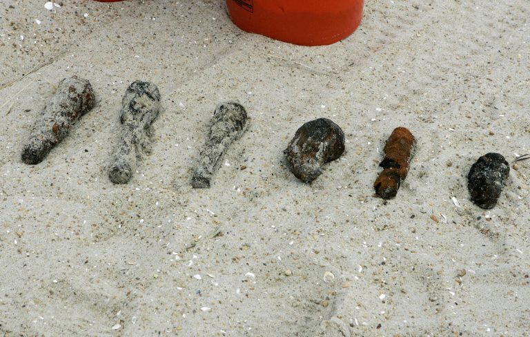 This Feb. 10, 2009 file photo shows some of the more than 1,100 old fuses and small anti-aircraft shells that have been found as the U.S. Army Corps of Engineers searches for any remaining World War I era munitions along the Atlantic Ocean in Surf City, N.J. A century after World War I ended, munitions from that and other wars continue to surface on beaches around the United States, usually during beach replenishment projects when they are sucked from the ocean floor and pumped ashore onto the sand, or exposed by strong storms. (Mel Evans/AP Photo, File)