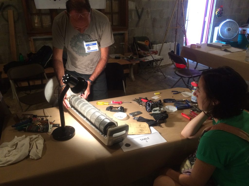 Luca Favaro tries to repair an old oscillating fan that isn't blowing any air out.