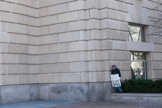 A lone protestor takes a break from the large during the March for Our Lives Saturday in Washington D.C. (Brad Larrison for WHYY)