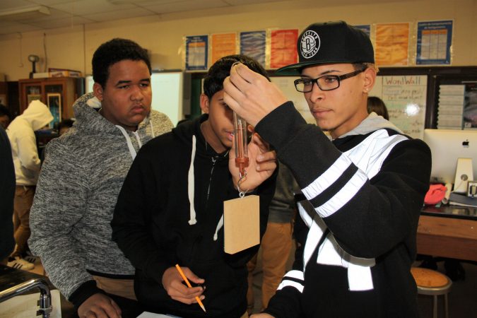 From left, Anderlis Martinez, Pedro Rosa and Jorge Suero are taking a Spanish-language physics course at Woodrow Wilson High School in Camden, New Jersey, as part of an effort to prepare more students for STEM careers. (Tara García Mathewson/The Hechinger Report)