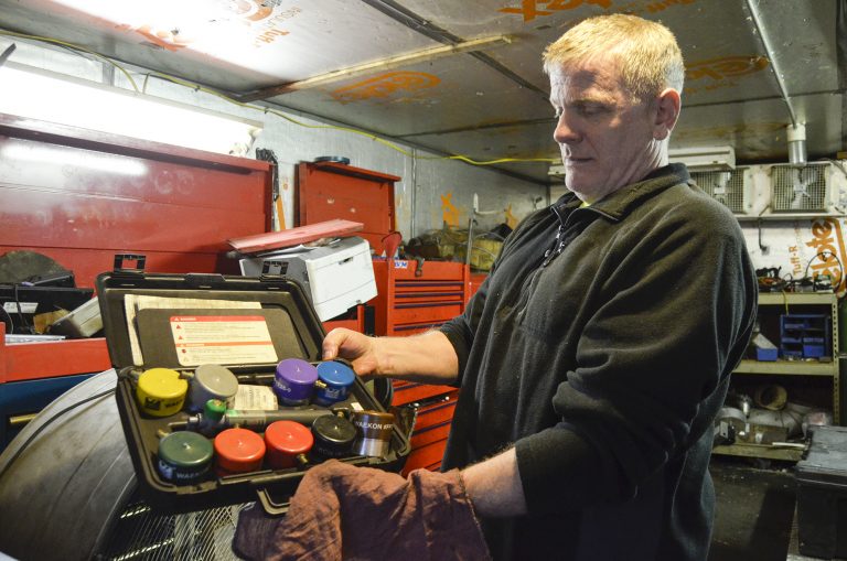 Scott Reynolds, owner of Express Transmission in Beaver County, shows an array of gas cap adapters. The adapters are used as a part of Pennsylvania's vehicle emission testing program. (Amy Sisk/StateImpact Pennsylvania)