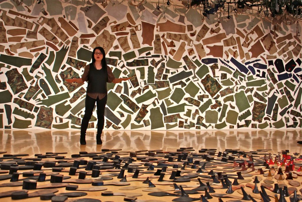 Jean Shin uses discarded objects to create monumental artworks. She stands between 