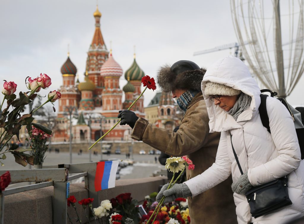 Russia Nemtsov People lay flowers at the place where Russian opposition leader Boris Nemtsov was gunned down, next to the Kremlin Wall, in Moscow, Russia, Sunday, Feb. 25, 2018. Thousands of Russians took to the streets of downtown Moscow to mark three years since Nemtsov was gunned down outside the Kremlin. (AP Photo/Alexander Zemlianichenko)