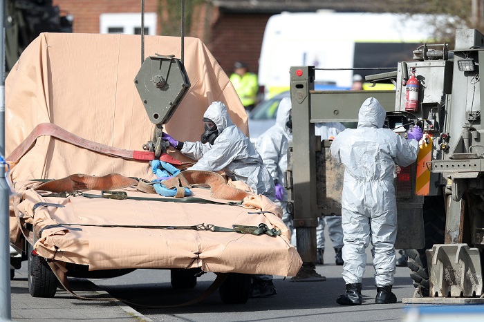 Britain Spy Soldiers wearing protective clothing prepare to lift a tow truck in Hyde Road, Gillingham, Dorset, England as the investigation into the suspected nerve agent attack on Russian double agent Sergei Skripal continues Wednesday March 14, 2018. The army cordoned off a road in Dorset on Wednesday as the investigated the attack on Sergei Skripal and his daughter Yulia. Authorities have cordoned off several sites in and near Salisbury, 90 miles (145 kilometers) southwest of London as part of their probe. (Andrew Matthews/PA via AP)