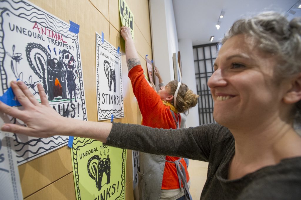 2018 04 08-j wilson-philadelphia pafa-chuck close protest posters Women cover the closed doors to the Chuck Close gallery at the Pennsylvania Academy of Fine Arts with protest posters featuring a drawing of a skunk and reading