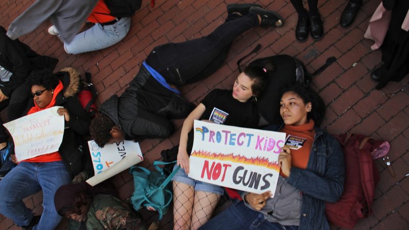 CAPA high school students (from right) Jordan Gibson and Alexandra Britton, participate in a die-in at Philadelphia City Hall, part of a national day of protest against gun violence on the 19th anniversary of the Columbine school shooting. (Emma Lee/WHYY)