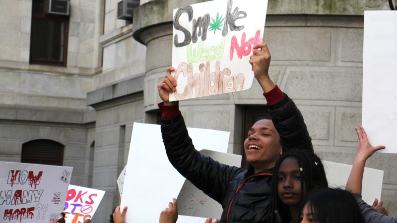 Students carry signs during a protest against gun violence at City Hall. (Emma Lee/WHYY)