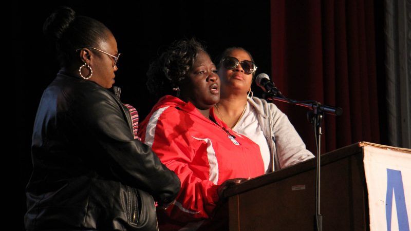 Gratz school parent leader Monica Haynesworth (center) talks about the shooting death of her 16-year-old son in 2014. She is flanked by two women who also lost sons to gun violence. (Emma Lee/WHYY)