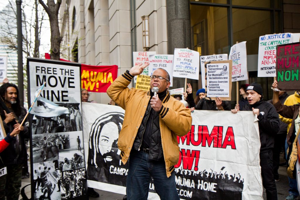 2018 4 30 k paynter zayid muhammad free mumia rally criminal justice center philadelphia Zayid Muhammad leads a rally for the release of Mumia Abu-Jamal outside the Philadelphia Criminal Justice Center Monday morning. (Kimberly Paynter/WHYY)