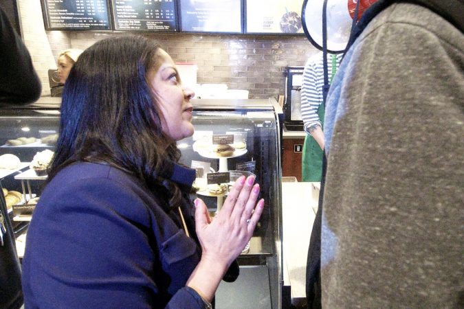 Camille Hymes, regional vice president of Starbucks, speaks to protesters gathered inside the store at 18th and Spruce streets in Philadelphia. (Bastiaan Slabbers/for WHYY)