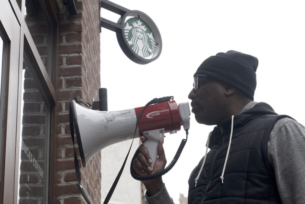 20180415_Starbucks_Protest_BS1419_009__BAS3851 Asa Khalif of Black Lives Matter uses a bullhorn during an April protest at Starbucks in Center City Philadelphia. (Bastiaan Slabbers/for WHYY)
