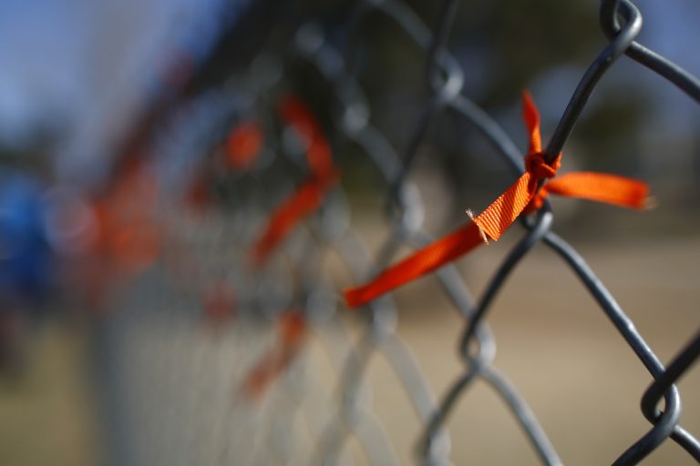 A orange ribbons adorns a fence after it was put there by a student during a walkout to protest gun violence on the soccer field behind Columbine High School Wednesday, March 14, 2018, in Littleton, Colo. More than 250 students took part in the short protest at Columbine, the scene of a mass school shooting on April 20, 1999. (David Zalubowski/AP Photo)