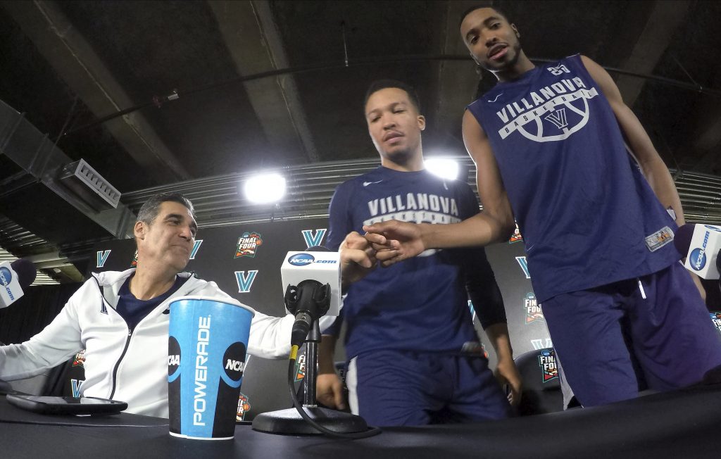 Villanova head coach Jay Wright, left, bumps his fist with Mikal Bridges as Jalen Brunson, center, and Bridges arrive at a news conference with head coach Jay Wright, left, and Mikal Bridges for the championship game of the Final Four NCAA college basketball tournament against Michigan, Sunday, April 1, 2018, in San Antonio.