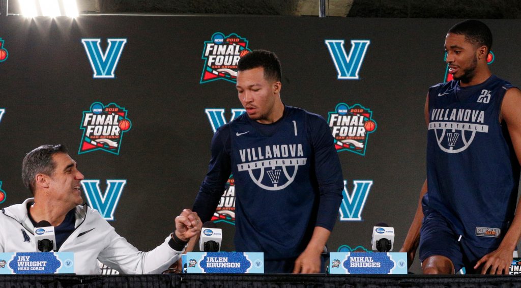 Final Four Michigan Villanova Basketball Villanova head coach Jay Wright, left, offers to bump his fist as Jalen Brunson and Mikal Bridges arrive at a news conference for the championship game of the Final Four NCAA college basketball tournament, Sunday, April 1, 2018, in San Antonio. (AP Photo/Brynn Anderson)
