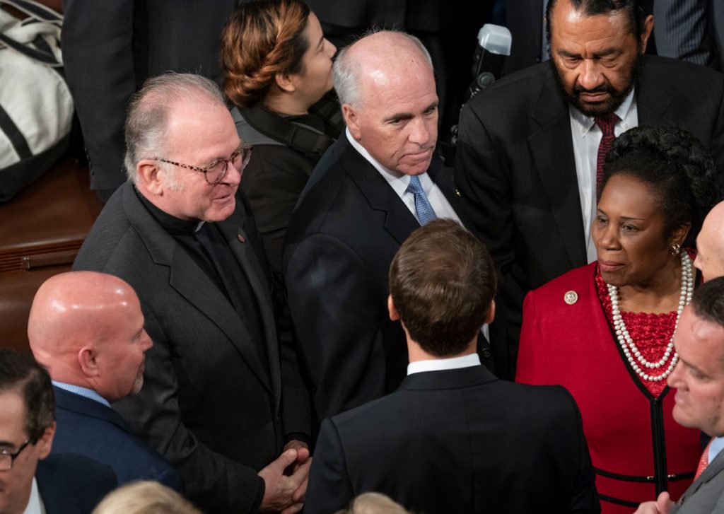 AP_18120493695025 Chaplain of the House of Representatives Father Patrick J. Conroy, upper left, speaks with French President Emmanuel Macron, bottom enter, at the Capitol in Washington, Wednesday, April 25, 2018. (AP Photo/J. Scott Applewhite)