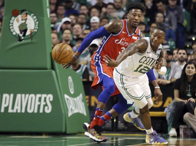 Boston Celtics guard Terry Rozier (12) passes the ball against the defense of Philadelphia 76ers forward Robert Covington (33) in the first quarter of Game 1 of an NBA basketball second-round playoff series, Monday, April 30, 2018, in Boston. (AP Photo/Elise Amendola)