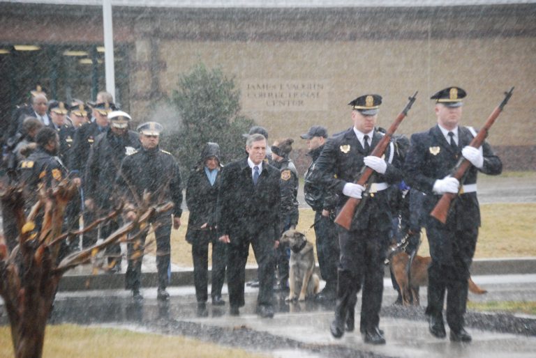 Memorial for Lt. Floyd Delaware is offering $3,000 signing bonuses to new correctional officers. In this photo, Gov. John Carney (center, in dark suit) attends a memorial service for Lt. Steven Floyd, who was killed during an uprising by prison inmates in February 2017. (John Jankowski/for WHYY)
