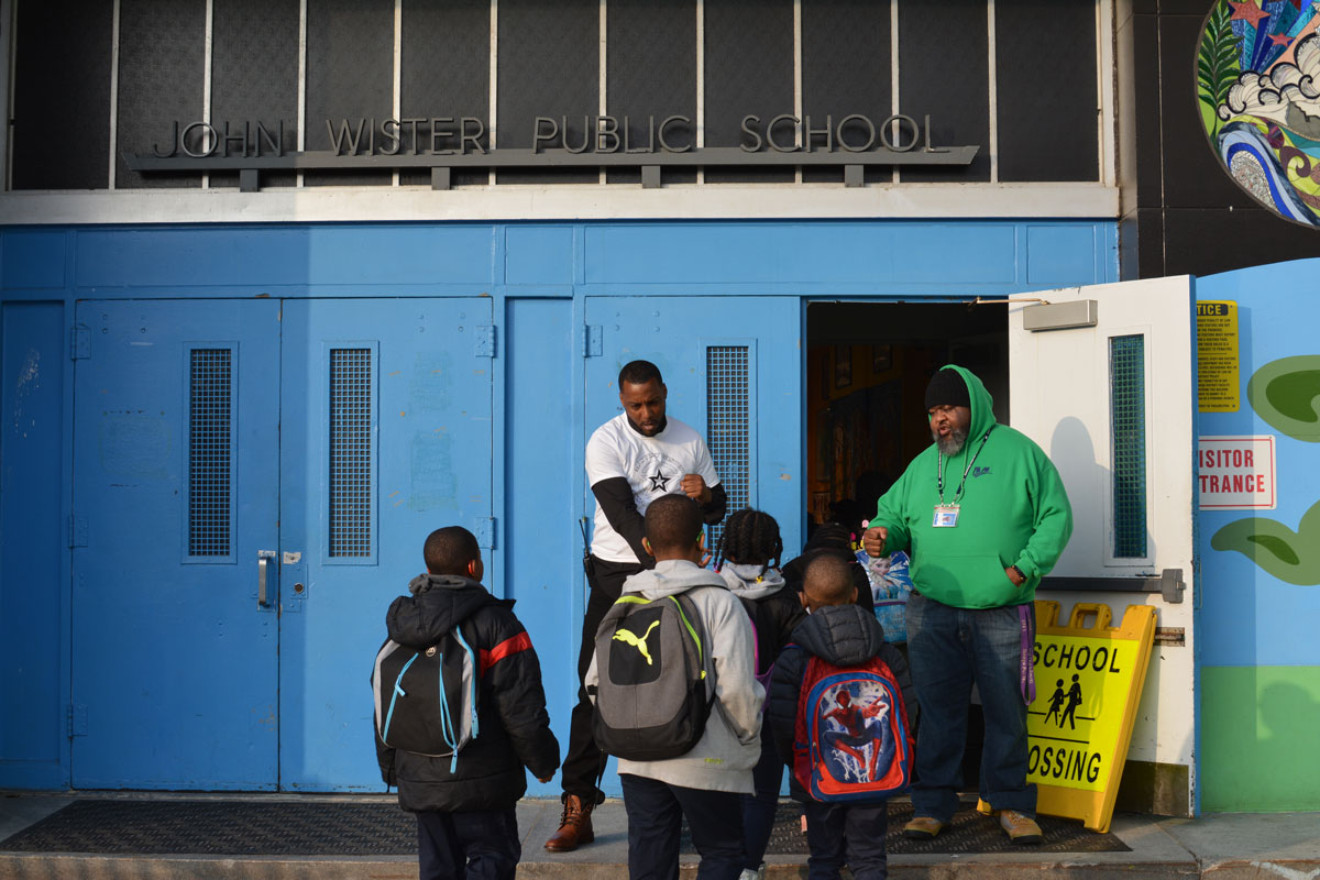 Jovan and Rudolph Williams, one of Wister's deans, greet students as they arrive at school during year two of the transition. (Kevin McCorry/WHYY)