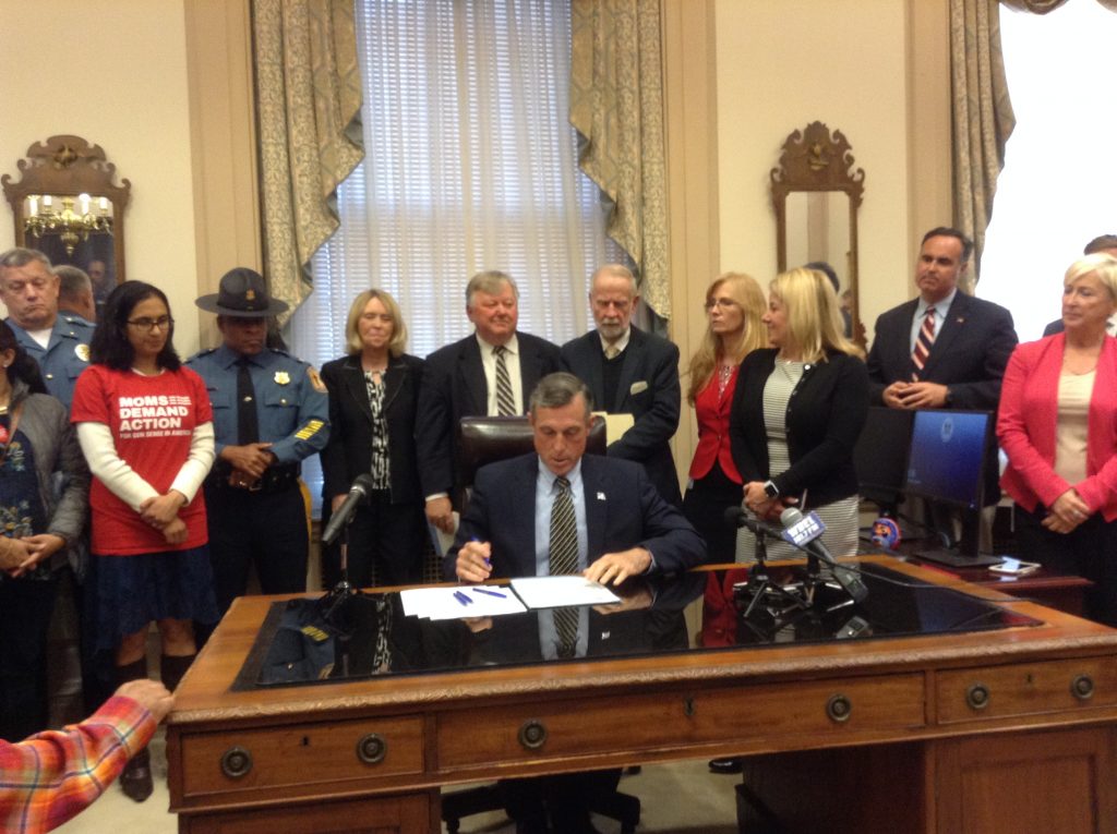 IMG_0456 Delaware Gov. John Carney signs legislation Wednesday that raises the maximum sentence for the illegal purchase, transfer or possession of a firearm. (Zoe Read/WHYY)