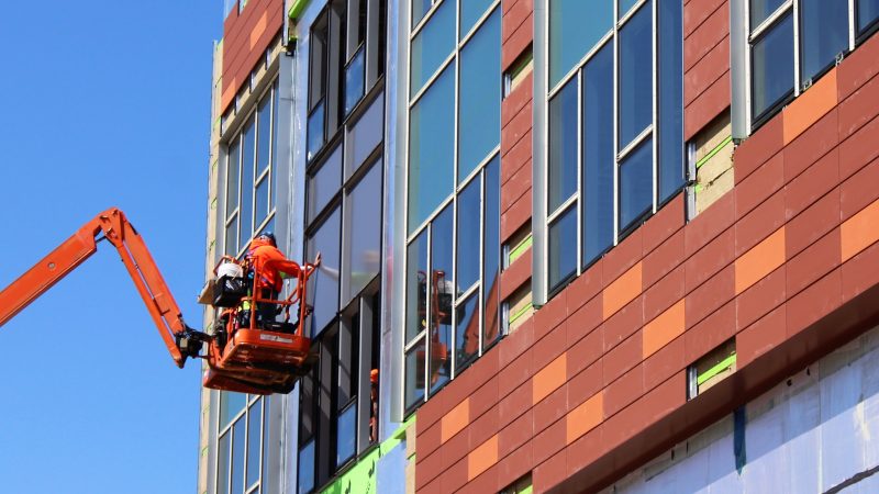 A worker finishes the windows on Stockton University’s new academic building in Atlantic City. (Bill Barlow/for WHYY)