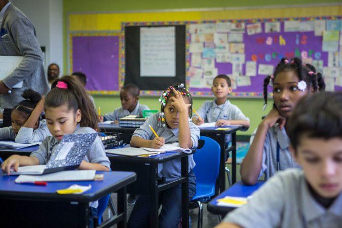 A fourth-grader in the math class that Jovan adopted works on a problem. (Jessica Kourkounis/WHYY) 