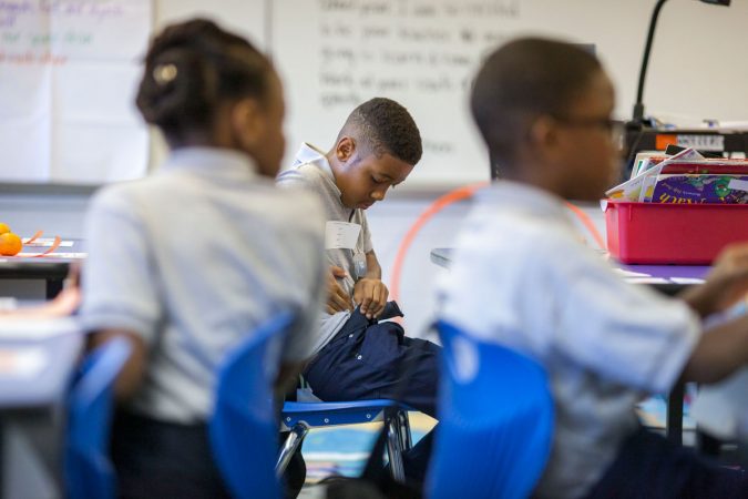 A student at Wister tucks in his shirt, adhering to the school's uniform policy. (Jessica Kourkounis/WHYY)