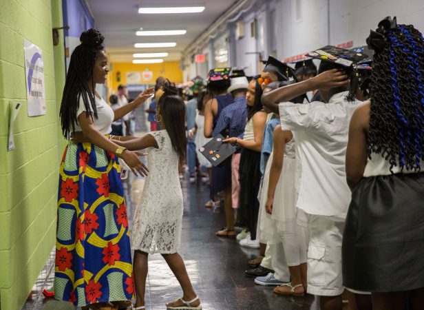 Shantel Shaw helps organize students before the graduation ceremony. (Lindsay Lazarski/WHYY)