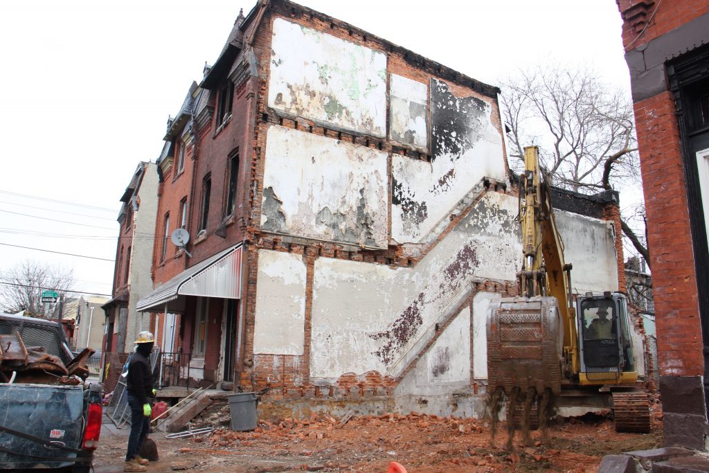 a-backhoe-works-on-the-lot-adjacent-to-1855-n-21st-st-where-four-people-were-killed-in-a-fire-emma-lee-whyy.original-e1522272880370 A backhoe operates on the lot adjacent to 1855 N. 21st St. in Philadelphia where four people died in a fire last month. (Emma Lee/WHYY)
