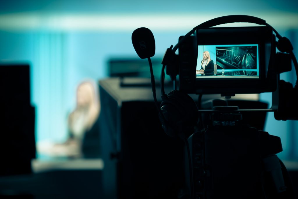 Young beautiful blonde television announcer at studio during liv TV NEWS studio with camera