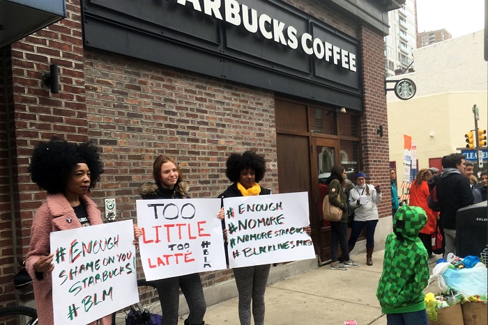 Starbucks-Black Men Arrested Protesters gather outside a Starbucks in Philadelphia, Sunday, April 15, 2018, where two black men were arrested Thursday after Starbucks employees called police to say the men were trespassing. The arrest prompted accusations of racism on social media. Starbucks CEO Kevin Johnson posted a lengthy statement Saturday night, calling the situation