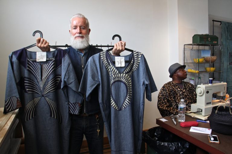 Bryan Norris, founder of the Refugee Makers Project in Lancaster, holds two caftans, which creator Remmy Kasongo calls bubus.