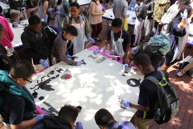 Students from Dunbar Promise Academy and other Philadelphia schools participate in the painting of the Octavius Catto mural during a community painting session at City Hall. (Emma Lee/WHYY)