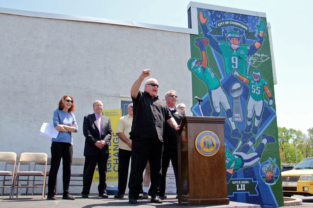 2018 05 08-e lee-bill bergey-philadelphia spikes trophies-super bowl mural Retired football player Bill Bergey leads fans in an E-A-G-L-E-S chant at the dedication of a David McShane mural at Spike's Trophies in Northeast Philadelphia commemorating the team's Super Bowl win.