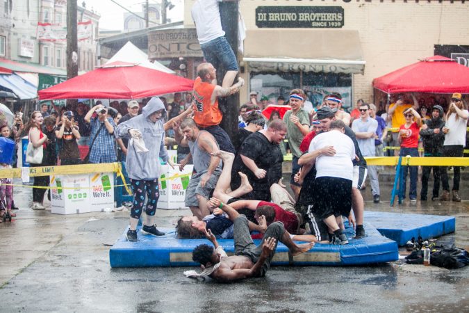 As a heavy rain started to fall the South Philly team who has competed in past years tries to climb the grease pole anyway. (Brad Larrison for WHYY)
