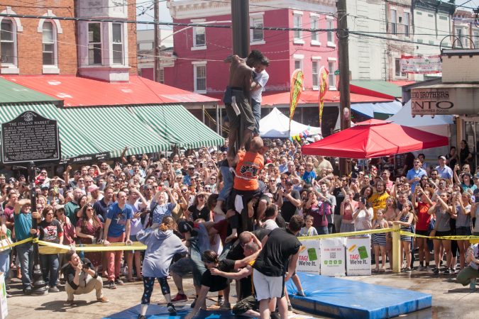 Team South Philly made another attempt at ascending the grease pole Sunday at the Italian Market Festival. (Brad Larrison for WHYY)