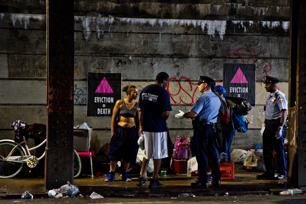 2018 5 30 kpaynter heroin encampment cleanup housig protest-4 Philadelphia police speak to residents of a homeless encampment at Kensington and Lehigh avenues before a scheduled clean out in May 2018. (Kimberly Paynter/WHYY)