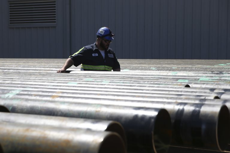 William Hampton walks between steel pipes at the Borusan Mannesmann plant in Baytown, Texas, Monday, April 23, 2018.  (AP Photo/Loren Elliott)