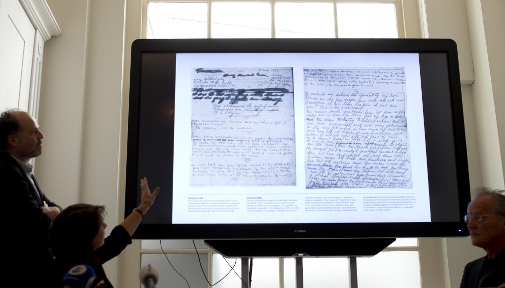 A video shows the text underneath two taped off pages from Anne Frank's diary during a press conference at The Anne Frank Foundation's office in Amsterdam, Netherlands, Tuesday, May 15, 2018. Left standing is the foundation's director Ronald Leopold. (Peter Dejong/AP Photo)