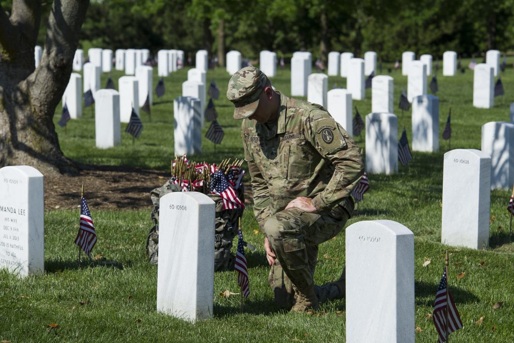 Memorial Day Arlington A member of the Army 3d U.S. Infantry Regiment, The Old Guard, pauses to honor a fallen soldier while places flags a the gravesite of the nation's fallen military heroes during its annual Flags In ceremony at Arlington National Cemetery, Thursday, May 24, 2018, in Arlington, Va. (AP Photo/Cliff Owen)