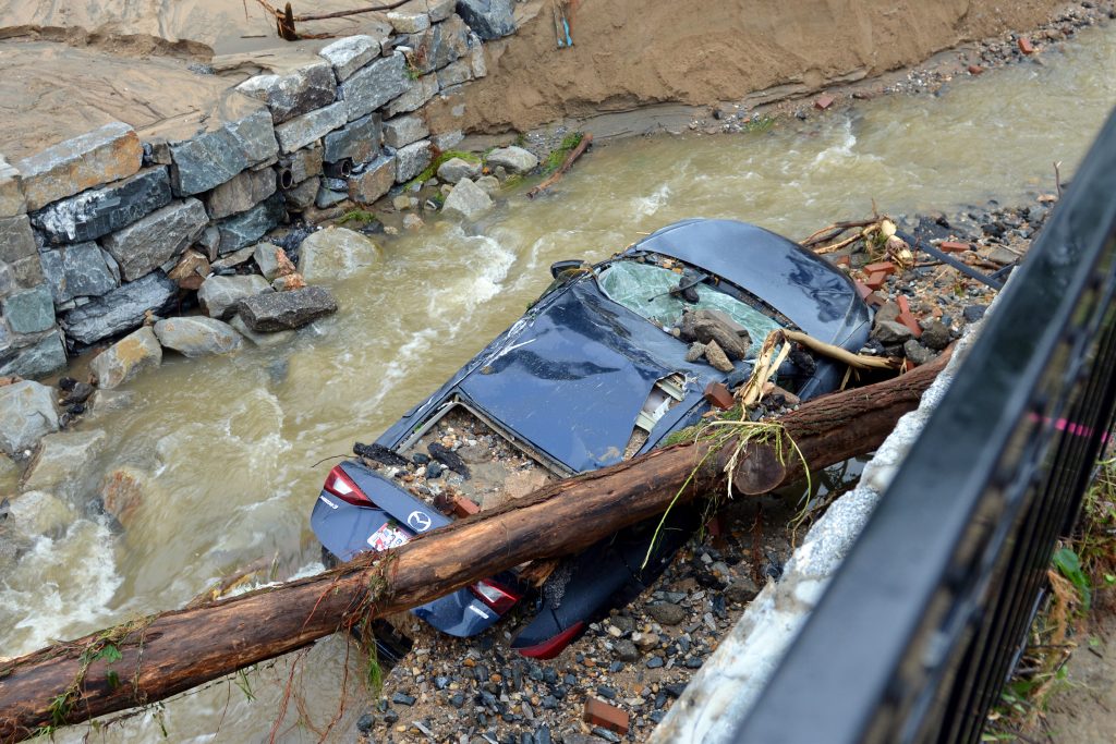 Maryland Flash Flooding Water moves past a car swept into the riverbank and smashed by a fallen tree is shown just off Main Street in flood-ravaged Ellicott City, Md., Monday, May 28, 2018. Sunday's destructive flooding left the former mill town heartbroken as it had bounded back from another destructive storm less than two years ago. (AP Photo/David McFadden)